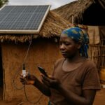 Frau lädt Telefon an Solarzellen